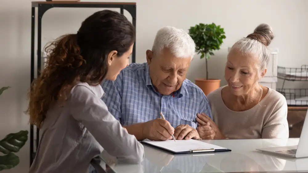 An elderly couple signing a document