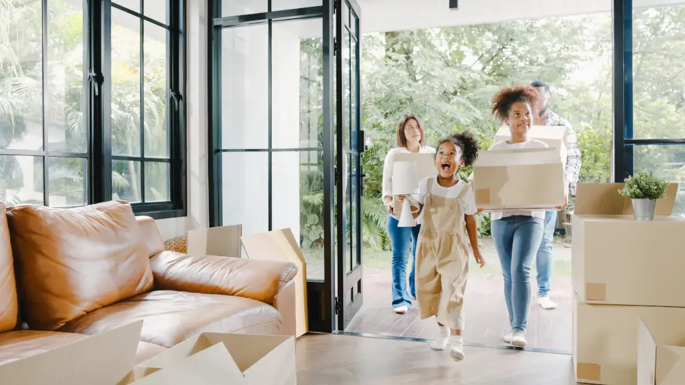 A happy family walking into their new home with boxes